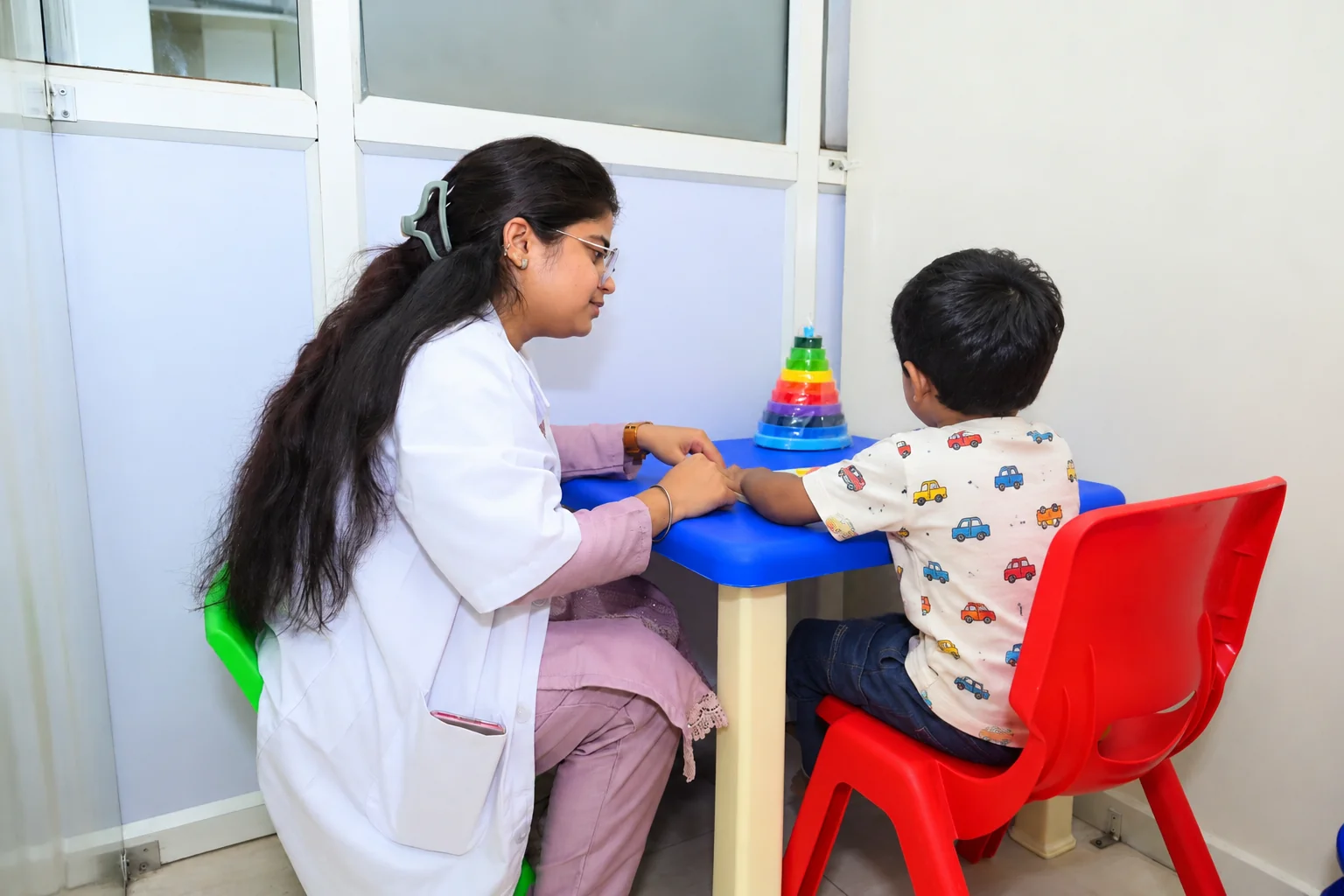 Child engaged in a structured developmental activity with a caregiver